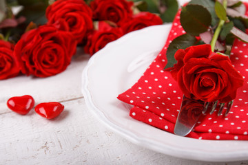 Valentines day table setting with plate, knife, fork, napkin and red roses. Valentines day...