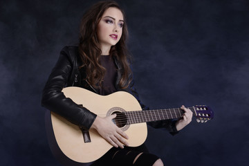 Fototapeta na wymiar Young teenage girl playing on guitar.