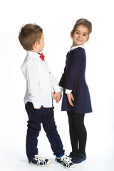 Cute boy and girl or teenagers in full length casual style blue jeans posing