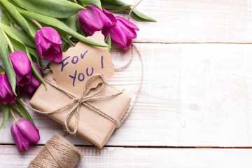 words FOR YOU and bouquet of tulips on wooden background