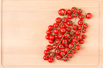 Tomatoes on wooden cutting board.