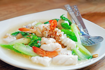 Thai food, Noodles in Thick Gravy with Seafood, Rad Na Ta Lay, on a wooden table.