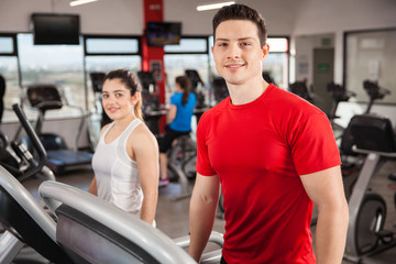 Fototapeta na wymiar Good looking couple exercising at the gym
