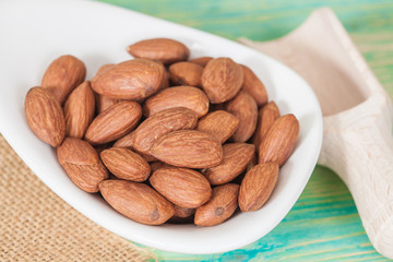 Almonds in bowl on wood