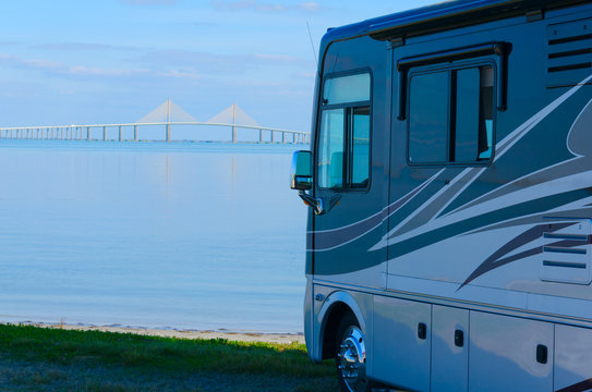 RV recreational vehicle is parked at the beach overlooking Tampa Bay in Fllorida with the Skyway Bridge in the background