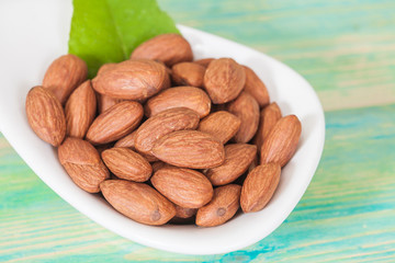Almonds in bowl on wood