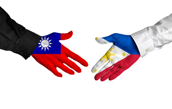 Taiwan and Philippines leaders shaking hands on a deal agreement