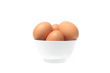 Brown eggs in bowl on white background