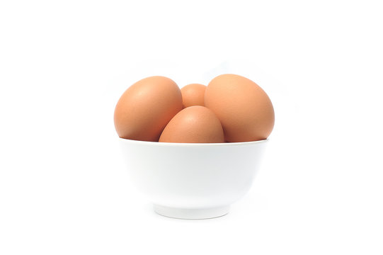 Brown eggs in bowl on white background