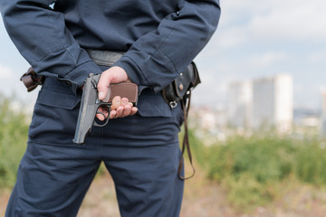 Detail of a police officer holding gun. Selective focus with shallow depth of field.