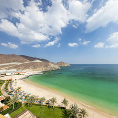 view to palm sand beach and ocean with sky clouds in day light in emirates
