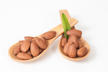 almonds in wood spoon on white background