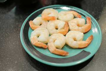 Boiled shrimp on a green dish.