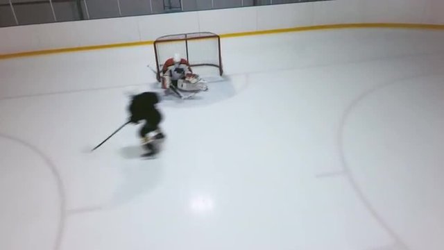 High angle view of goaltender defending the net by catching pucks on his stick