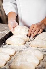 Midsection Of Woman Keeping Bread Dough In Baking Tray