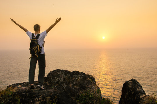 Man on the cliff selebrating success and feeling freedom