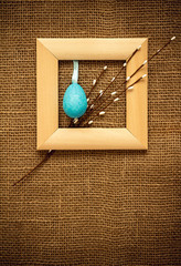 Easter background with a willow branch and a blue egg