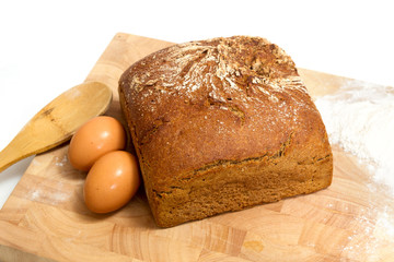 rye bread and eggs on wood with white background