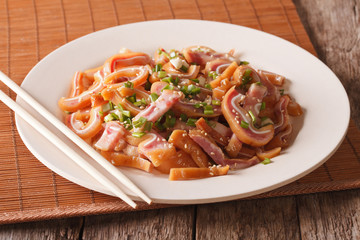 fried pig ears with sesame seeds and green onions close-up. Horizontal
