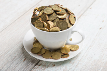 cup of coffee with gold coins of malaysian ringgit