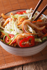 salad of pork ear and vegetables close-up in a bowl. vertical
