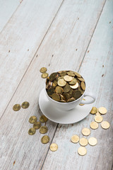 cup of coffee with gold coins of malaysian ringgit