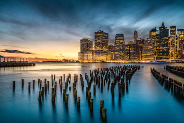 Lower Manhattan with sunset view from Brooklyn Bridge Park in New York City.
