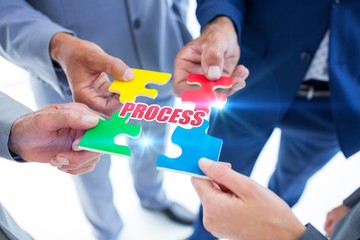 Process against business colleagues holding piece of puzzle