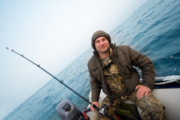 Fisherman catches a salmon in the sea