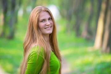 Naklejka premium Pretty woman with red hair in the park