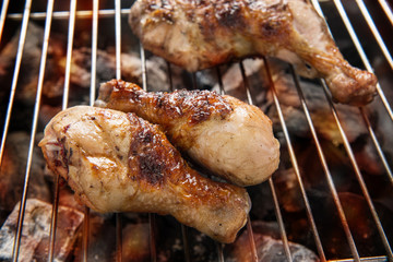 Grilled chicken drumstick over flames on a barbecue