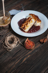Berry drink. Saucer kissel with cheese casserole and spices on wood