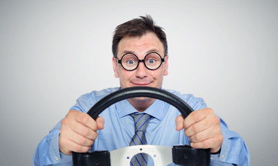 Funny businessman in glasses with a steering wheel, car drive concept 