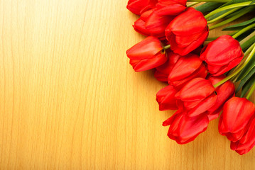 Red tulips on a wooden background