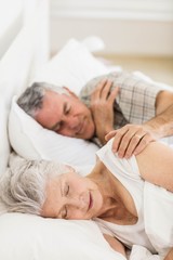 Fototapeta na wymiar Senior couple sleeping in bed at home