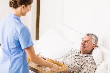 Fototapeta premium Nurse taking care of suffering senior patient 