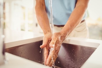 Mid section of senior man washing hands