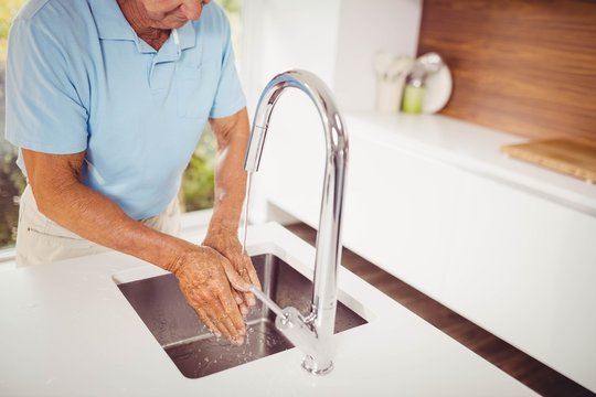 Mid Section Of Senior Man Washing Hands