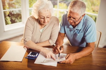 Senior couple counting bills - Powered by Adobe