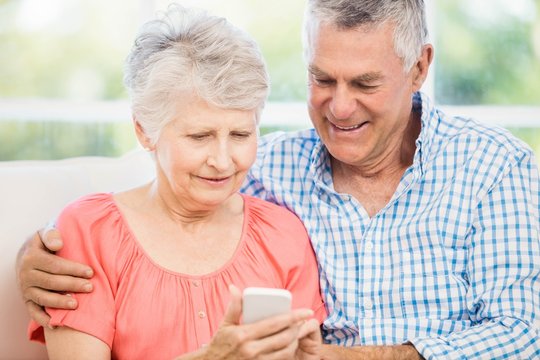 Smiling Senior Couple Using Smartphone