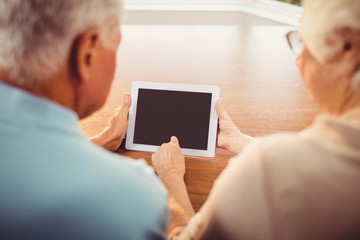 Rear view of senior couple using tablet