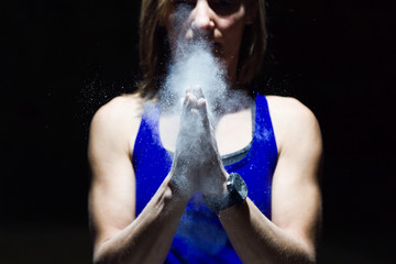 Fototapeta na wymiar Climber woman coating her hands in powder chalk magnesium.