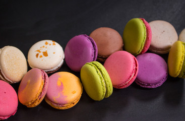Assorted colorful macaroons on a dark background