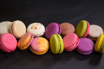 Assorted colorful macaroons on a dark background