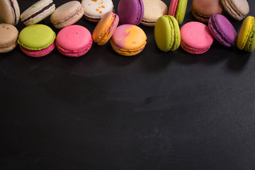 Assorted colorful macaroons on a dark background