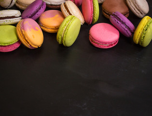 Assorted colorful macaroons on a dark background