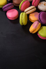 Assorted colorful macaroons on a dark background