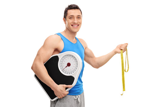 Cheerful athlete holding a weight scale