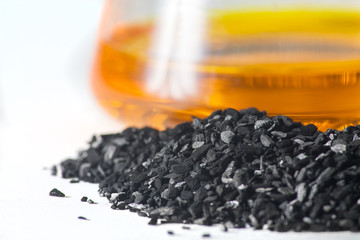 loose coal on the background of glass test tubes with colored li