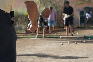 Senior playing petanque, balls on the ground